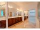 Bathroom with dual vanities, mirrored walls, tile floors and walk-in closet at 4702 N 151St Dr, Goodyear, AZ 85395