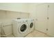 Functional laundry room featuring white appliances and tile flooring at 4702 N 151St Dr, Goodyear, AZ 85395