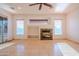 Bright living room with fireplace, tile flooring, ceiling fan, and plenty of natural light from the windows and sliding glass door at 4702 N 151St Dr, Goodyear, AZ 85395