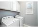 Bright laundry room with a washer, dryer, white cabinets, and a window with white shutters at 4777 S Fulton Ranch Blvd # 1098, Chandler, AZ 85248