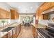 Galley kitchen featuring wood cabinets, granite counters, stainless steel appliances, and eat-in breakfast nook at 6208 W Willow Ave, Glendale, AZ 85304