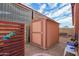 Backyard shed with brown trim and accents, next to a wood fence at 6208 W Willow Ave, Glendale, AZ 85304