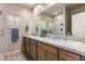 Bright bathroom featuring a double sink vanity with granite countertops and a large mirror at 6998 E Soaring Eagle Way, Scottsdale, AZ 85266