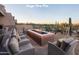 Outdoor lounge area featuring a large, modern fire pit with desert landscape and mountain views at 6998 E Soaring Eagle Way, Scottsdale, AZ 85266