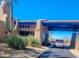 Community entrance with a covered drive-through, desert plants, and manicured landscaping at 7016 E Stone Raven Trl, Scottsdale, AZ 85266