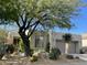 Charming desert home featuring barrel cactus, desert landscaping, and an attached two-car garage at 7016 E Stone Raven Trl, Scottsdale, AZ 85266