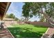 Expansive backyard featuring a pergola, artificial grass, and a brick perimeter at 7259 W Tina Ln, Glendale, AZ 85310