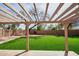 Pergola-covered patio overlooking an artificial grass backyard at 7259 W Tina Ln, Glendale, AZ 85310