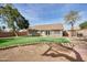 This backyard features lush artificial grass, a patio, and mature trees at 7259 W Tina Ln, Glendale, AZ 85310