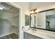 Bathroom featuring a vanity with sink, mirror, and walk-in closet with shelving at 7259 W Tina Ln, Glendale, AZ 85310