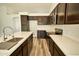 Modern kitchen with stainless steel appliances, a center island with a sink, and wood flooring at 7259 W Tina Ln, Glendale, AZ 85310