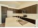 Spacious kitchen with stainless steel appliances, dark wood cabinets, an island, and white countertops at 7259 W Tina Ln, Glendale, AZ 85310