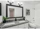 Well-lit bathroom boasts granite countertop vanity with dual sinks, large mirror, and shower-tub combo at 7270 W Tina Ln, Glendale, AZ 85310