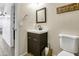 Well-lit half bathroom with a dark wood vanity and a decorative mirror at 7703 S 68Th Dr, Laveen, AZ 85339