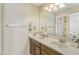 Bright bathroom features a double sink vanity, large mirror, and decorative shelving for ample storage at 7703 S 68Th Dr, Laveen, AZ 85339