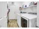 Functional laundry room featuring a washer and dryer, storage shelves, and clean white walls at 7703 S 68Th Dr, Laveen, AZ 85339