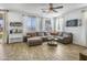 Cozy living room featuring a comfortable sectional sofa, wood-look tile flooring, and lots of natural light at 7703 S 68Th Dr, Laveen, AZ 85339