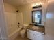 This bathroom features a shower-tub, a granite vanity and a mirror at 7728 W Via Montoya Dr, Peoria, AZ 85383