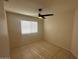 This bedroom features tile floors, a ceiling fan, and a window for natural light at 7728 W Via Montoya Dr, Peoria, AZ 85383