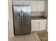 Kitchen view showcasing a modern stainless steel refrigerator, white cabinets, and granite counters at 7728 W Via Montoya Dr, Peoria, AZ 85383