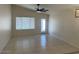 A spacious living room featuring tile flooring, a ceiling fan, and access to the backyard at 7728 W Via Montoya Dr, Peoria, AZ 85383