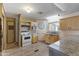 Well-lit kitchen with wood floors, white appliances, and light wood cabinets at 8103 E Southern Ave # 25, Mesa, AZ 85209