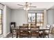 Bright dining area with large windows, ceiling fan, and wood table provides comfortable dining space at 8231 N 21St Dr # E101, Phoenix, AZ 85021