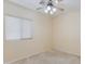 Bright bedroom with neutral walls, a ceiling fan, carpeted floor, and a window offering natural light at 8250 S Hidden Trail Ct, Gold Canyon, AZ 85118