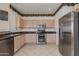 Well-equipped kitchen featuring stainless steel appliances, light wood cabinets, and tile flooring at 8250 S Hidden Trail Ct, Gold Canyon, AZ 85118