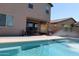 Backyard with a pool featuring a waterfall, covered patio, and desert landscaping at 8420 S 40Th Dr, Laveen, AZ 85339