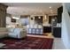 Spacious living room showcasing open layout, white sofa, patterned rug, and view of the modern kitchen at 8420 S 40Th Dr, Laveen, AZ 85339