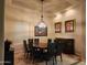 Well-lit dining room with a decorative chandelier, artwork, and a view of the outdoor living space at 8928 E Wethersfield Rd, Scottsdale, AZ 85260