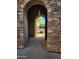 Inviting entryway with stone archway leading to the front yard at 8928 E Wethersfield Rd, Scottsdale, AZ 85260