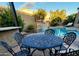 Outdoor patio with a dining table set next to a pool and beautiful stone waterfall feature at 8928 E Wethersfield Rd, Scottsdale, AZ 85260