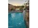 Resort-style pool with a rock waterfall feature and a pergola-covered dining area at 8928 E Wethersfield Rd, Scottsdale, AZ 85260