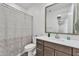 Well-lit bathroom featuring a modern vanity, a toilet, and a shower with decorative curtain at 9008 W Bethany Heights Dr, Glendale, AZ 85305