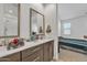 Bathroom with a gray vanity, a mirror and a view to a bedroom with bright light and a comfortable bed at 9008 W Bethany Heights Dr, Glendale, AZ 85305