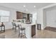 Bright kitchen featuring a spacious quartz countertop island with bar stool seating and a large stainless steel refrigerator at 9008 W Bethany Heights Dr, Glendale, AZ 85305