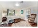 Cozy bedroom featuring wood floors, rocking chair, and a sliding glass door leading to a sunroom with comfortable seating at 9340 E Sun Lakes S Blvd, Sun Lakes, AZ 85248