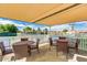 Shaded common area with tables and chairs overlooking tennis courts and blue skies at 9340 E Sun Lakes S Blvd, Sun Lakes, AZ 85248