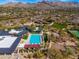 Aerial view of clubhouse, pool, basketball court, and playground, showcasing the community's amenities and mountain backdrop at 9565 E Mountain Spring Rd, Scottsdale, AZ 85255