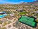 Wide aerial shot showcasing tennis courts, community pool and surrounding neighborhood at 9565 E Mountain Spring Rd, Scottsdale, AZ 85255