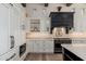 Close-up of the kitchen showcasing white cabinetry, black range hood, mosaic tile backsplash, and modern appliances at 9565 E Mountain Spring Rd, Scottsdale, AZ 85255