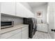 Laundry room with sleek washer/dryer, ample storage cabinets, and modern fixtures at 9565 E Mountain Spring Rd, Scottsdale, AZ 85255