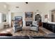 Bright living room featuring a fireplace, two armchairs, and natural light from a window at 9565 E Mountain Spring Rd, Scottsdale, AZ 85255