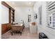 Bright home office with a wooden desk, built-in bookshelves, and natural light from the windows at 9565 E Mountain Spring Rd, Scottsdale, AZ 85255