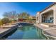 Backyard swimming pool with a waterfall feature and meticulously landscaped surroundings creating a private retreat at 9565 E Mountain Spring Rd, Scottsdale, AZ 85255