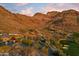 Beautiful desert home with a pool and golf course view, framed by picturesque mountain landscape under sunset skies at 9820 E Thompson Peak Pkwy # 629, Scottsdale, AZ 85255