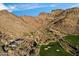 Aerial view showcasing the home nestled beside a lush golf course and rugged mountains at 9820 E Thompson Peak Pkwy # 629, Scottsdale, AZ 85255