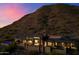 Luxury desert home nestled in mountains, featuring a pool and stone accents, set against a colorful dusk sky at 9820 E Thompson Peak Pkwy # 629, Scottsdale, AZ 85255